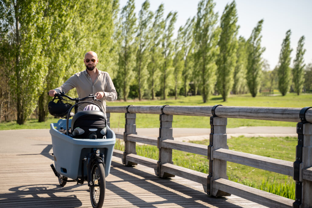 Dad is walking alongside his Dolly cargo bike